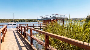 A wooden pier extending into a lake with boats docked nearby. - INSELHOTEL Potsdam - Hermannswerder (Potsdam)