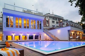 Un hotel moderno con piscina, una escalera y un área de descanso con vista a la piscina.