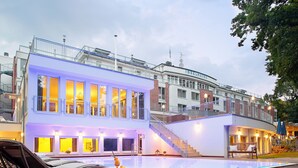 A modern hotel with a rooftop pool, outdoor seating, and a staircase leading to upper floors. - INSELHOTEL Potsdam - Hermannswerder (Potsdam)