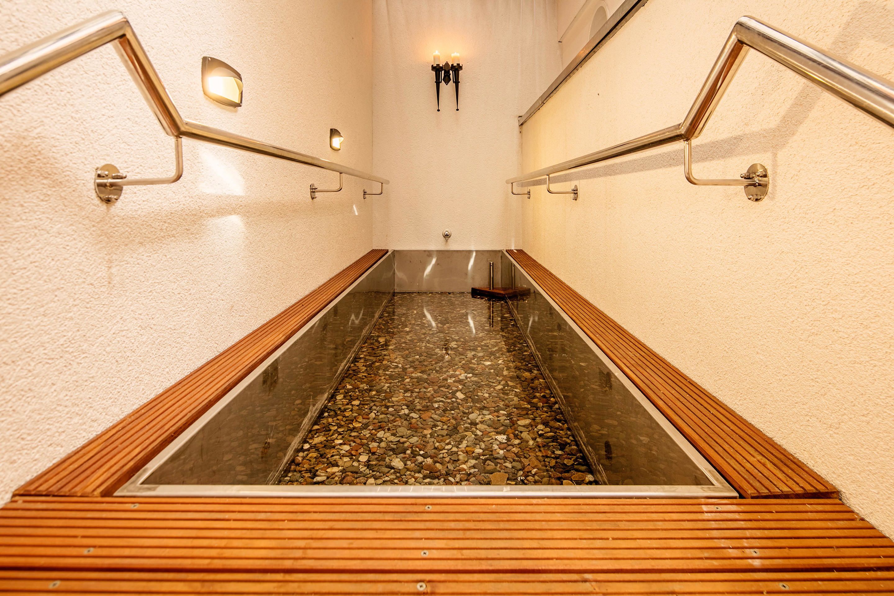 A wooden staircase with metal railings and a glass barrier at the bottom.