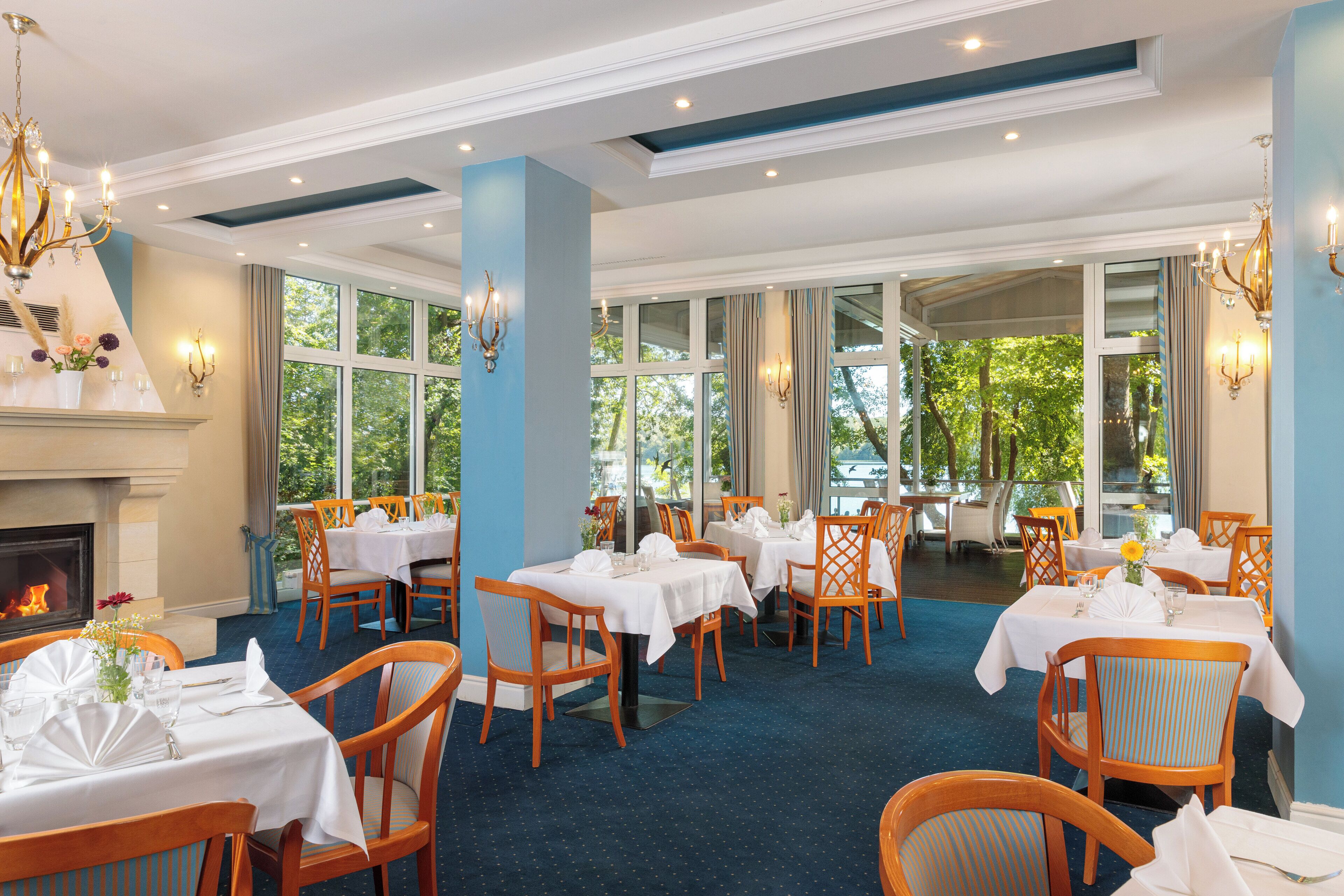 Un restaurante con varias mesas, sillas y una chimenea.