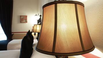 A hotel room with a bed, a lamp, and a painting on the wall.