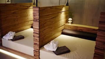 Una habitación moderna y acogedora con paneles de madera y dos camas con sábanas blancas y almohadas marrones.