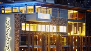 Un hotel moderno con un letrero llamativo que dice "SEEGARTEN" y fachada de vidrio.