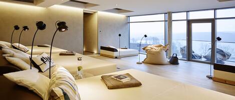 A modern living room with a sofa, a coffee table, and a view of the outdoors.
