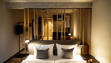 Ein Hotelzimmer mit einem großen Bett, zwei Nachttischen, einem Fernseher und einer Holzwand.