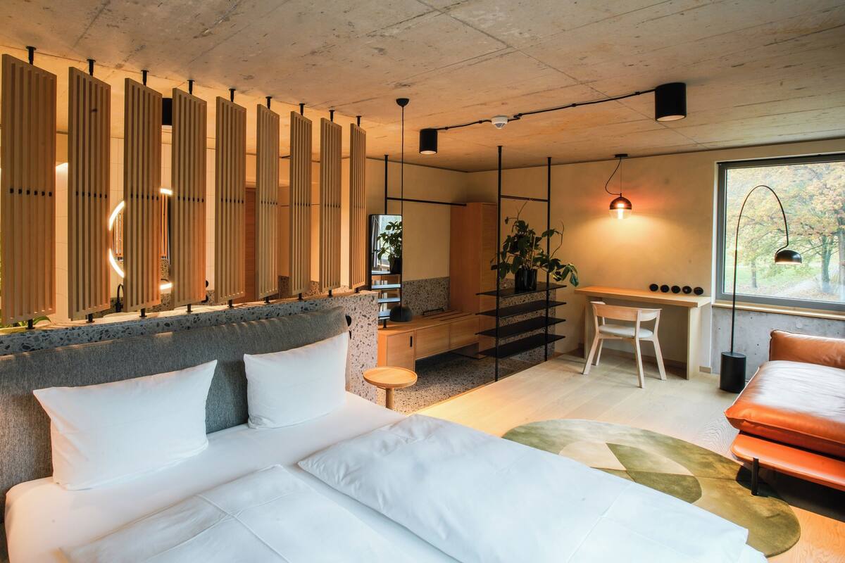 A modern bedroom with a bed, a desk, and a chair.