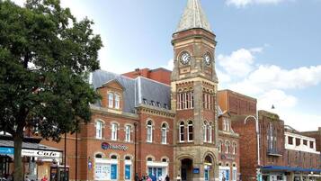 A historic building with a clock tower, a cafe, and a Travelodge hotel.