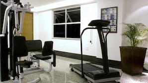 A home gym with a treadmill, weight bench, and a stationary bike. - Liber Hotel Nova Serrana (Nova Serrana)