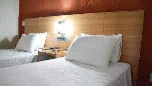 A hotel room with two single beds, wooden headboard, bedside tables, and a nightstand. - Liber Hotel Nova Serrana (Nova Serrana)
