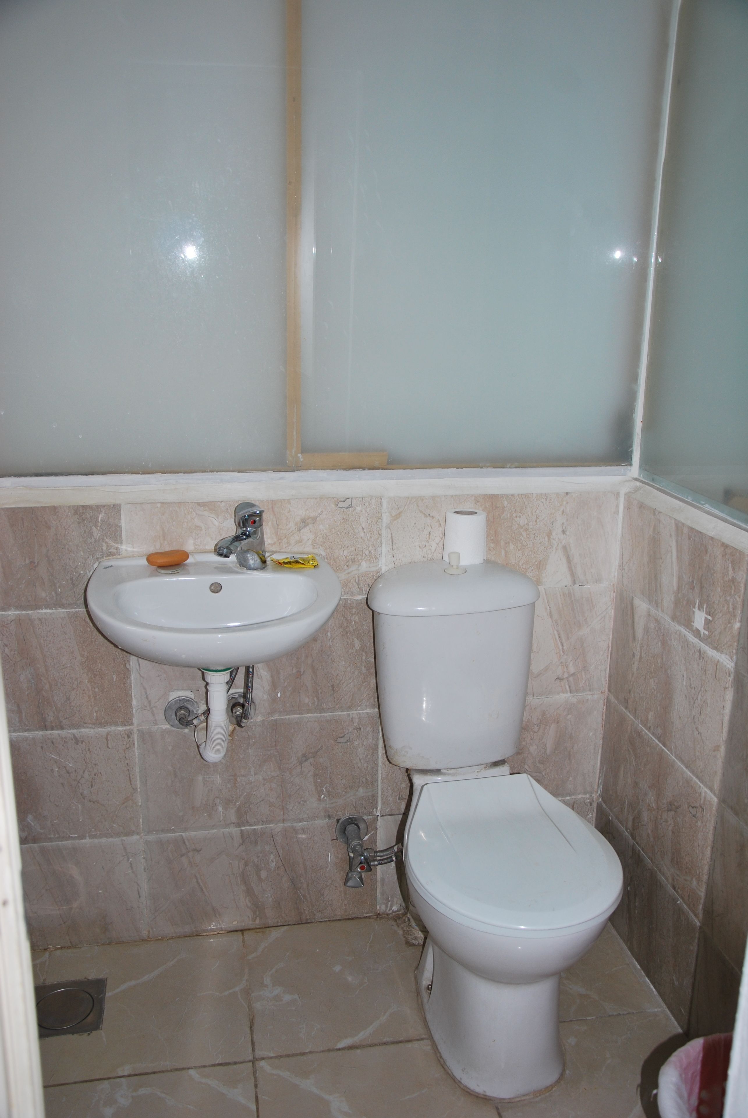 A bathroom with a sink, toilet, and a shower area.