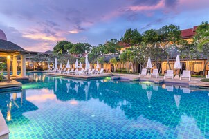 Una piscina al aire libre, sombrillas, sillones reclinables de piscina