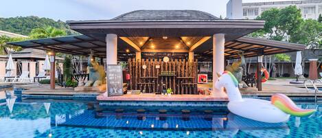 Uma área de bar à beira da piscina com um espaço coberto para sentar, um boi de água decorativo e vista para a paisagem circundante.