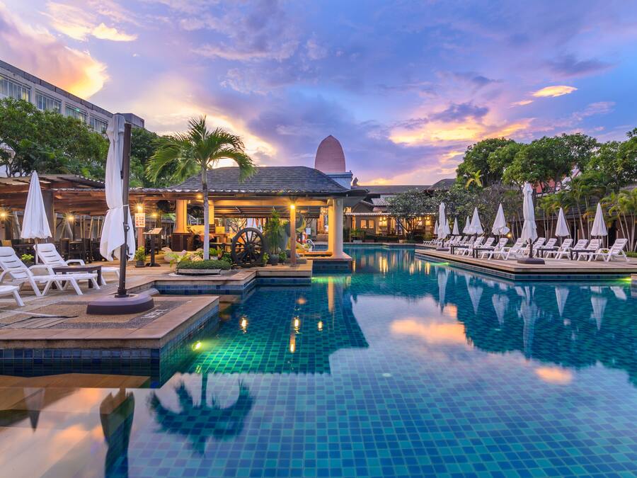 Una piscina al aire libre, sombrillas, sillones reclinables de piscina