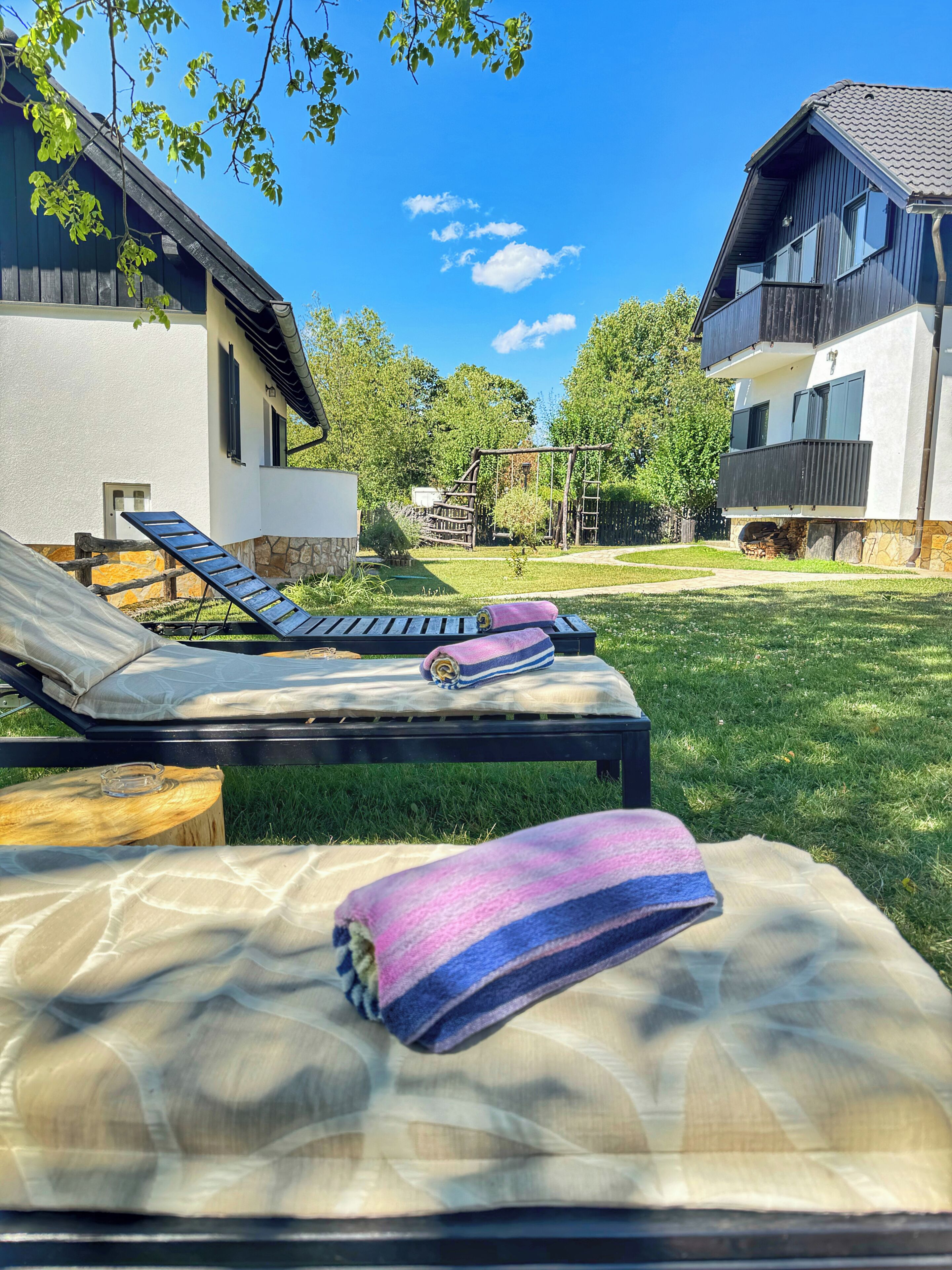 Ein Poolbereich mit Liegestühlen, einer Holzterrasse und einer Steinmauer.