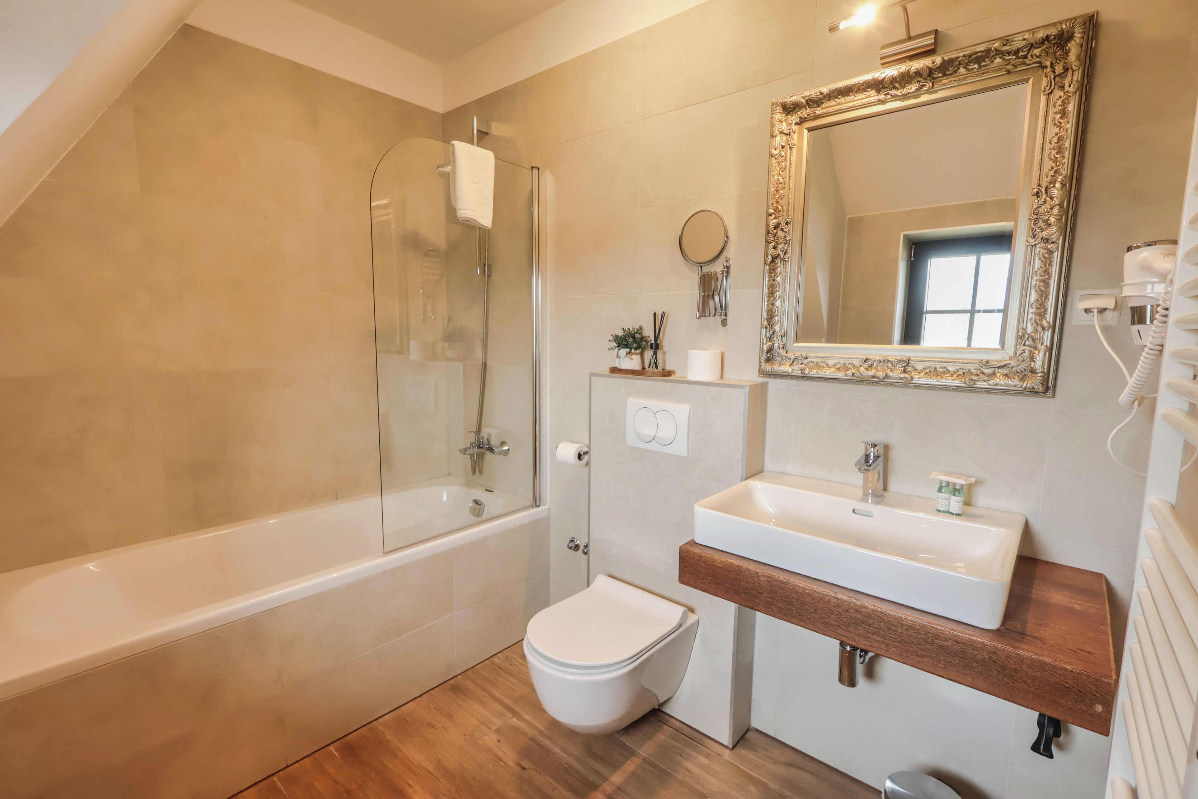 Une salle de bain moderne avec une baignoire, des toilettes, un lavabo et un grand miroir.