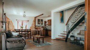 Un salón acogedor con un sofá, una mesa de comedor y una cocina al fondo.