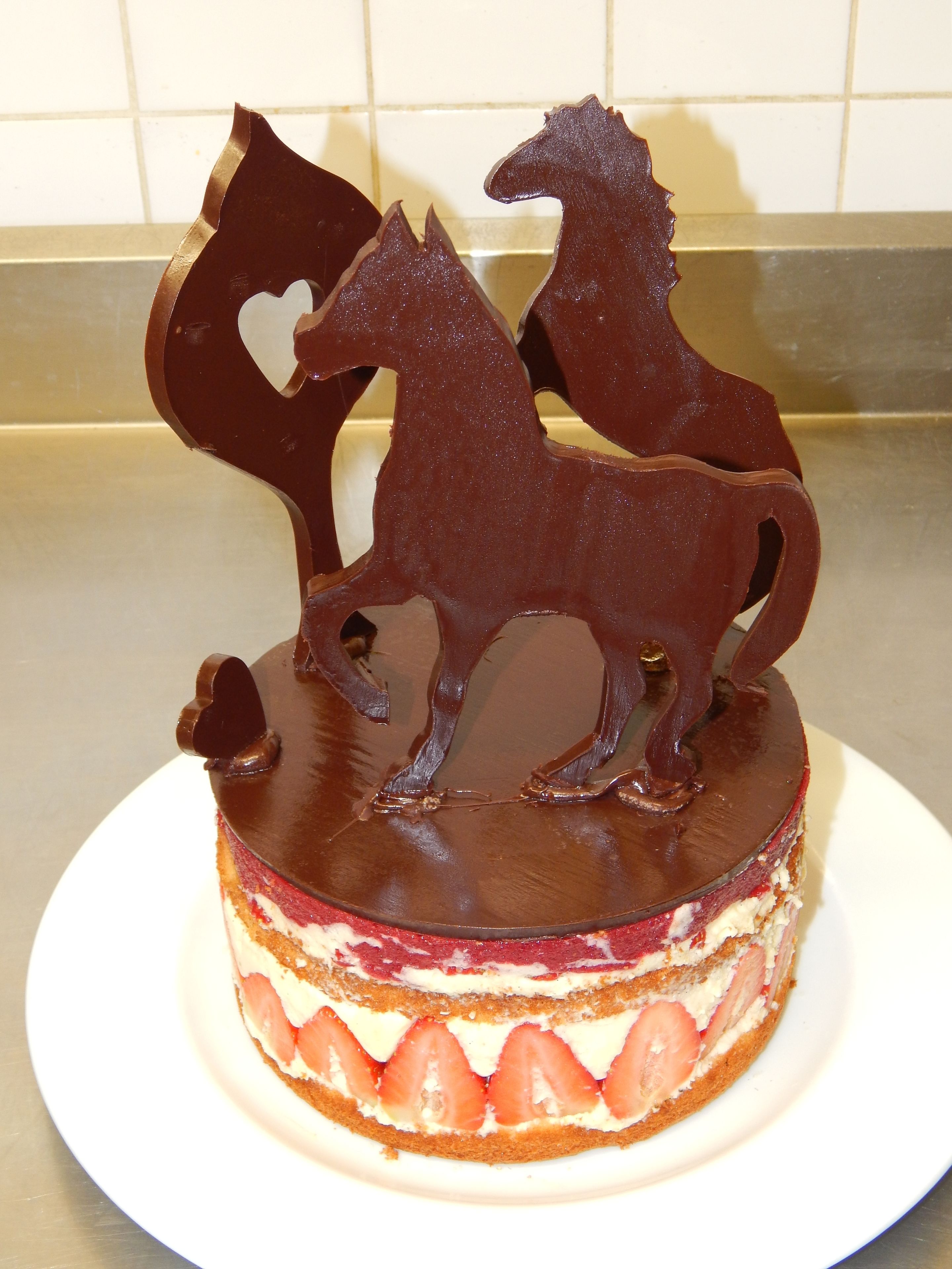 Un pastel con una decoración de caballo de chocolate encima.
