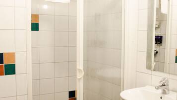 A bathroom with a shower, a sink, and a mirror.