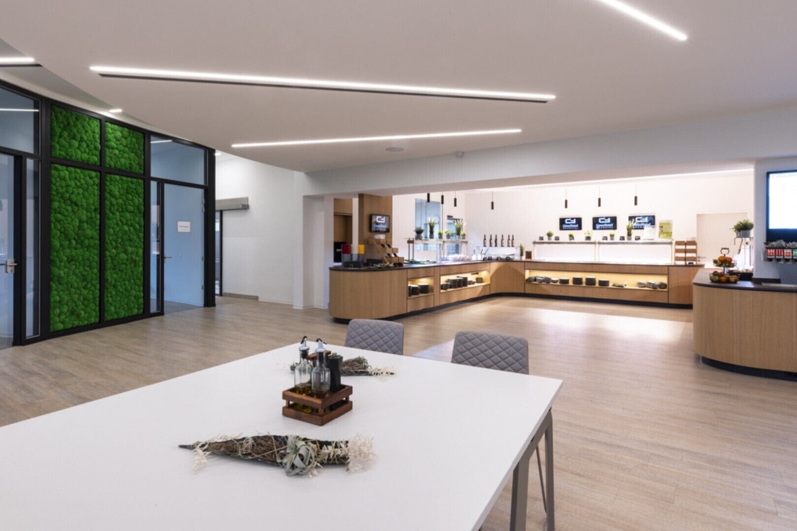 Una cocina moderna con una isla central, armarios de madera y una pared verde con textura.