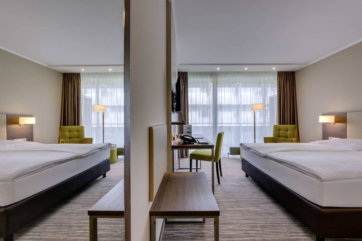 Una habitación de hotel con dos camas, un escritorio y una silla.