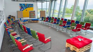 A spacious room with rows of colorful chairs and a central red cushioned bench.