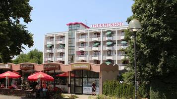 A hotel with multiple balconies, outdoor seating areas, and a sign for 'Café Elisabeth'.