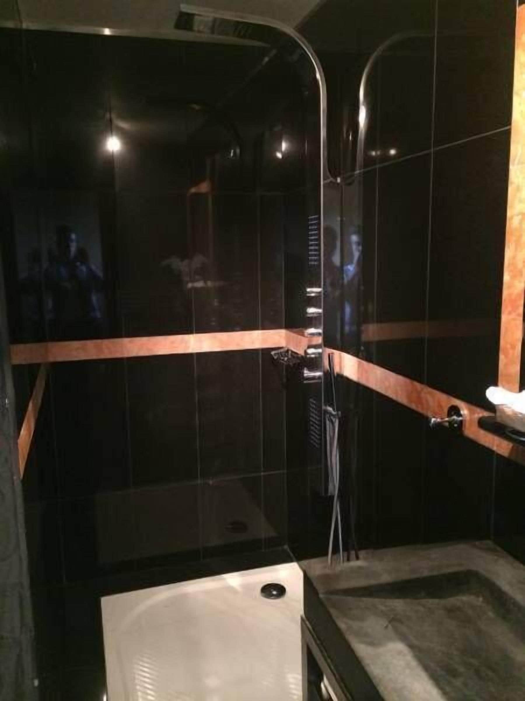 A modern bathroom with a glass-enclosed shower, a standalone bathtub, and a vanity with a mirror.