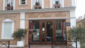 A hotel with a classic facade, large glass doors, and potted plants at the entrance. - Hôtel Saint Alban (Saint-Maur-des-Fosses)