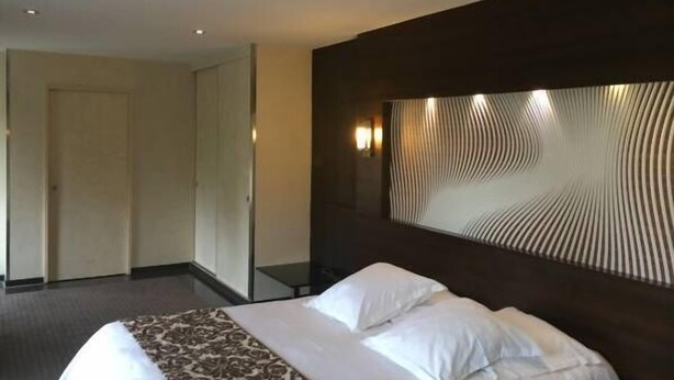 A hotel room with a large bed, a dark headboard, and a patterned throw. - Hôtel Saint Alban (Saint-Maur-des-Fosses)