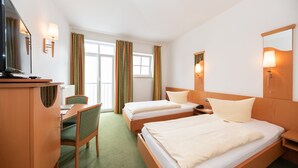 A hotel room with two beds, a desk, a chair, and a television. - Hotel Bitburger Hof (Bitburg)