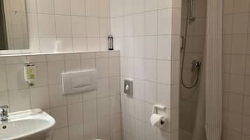 Ett badrum med handfat, toalett och dusch.