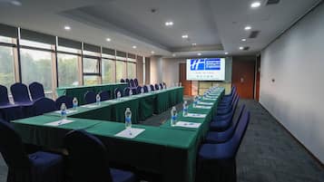 A conference room with a long table, chairs, and a projection screen.