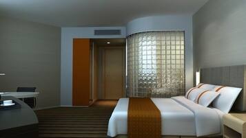 A modern hotel room with a bed, bedside table, and a desk with a chair.