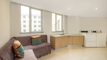 Ein modernes Apartment mit einer Couch, einer Küchenzeile und großen Fenstern.