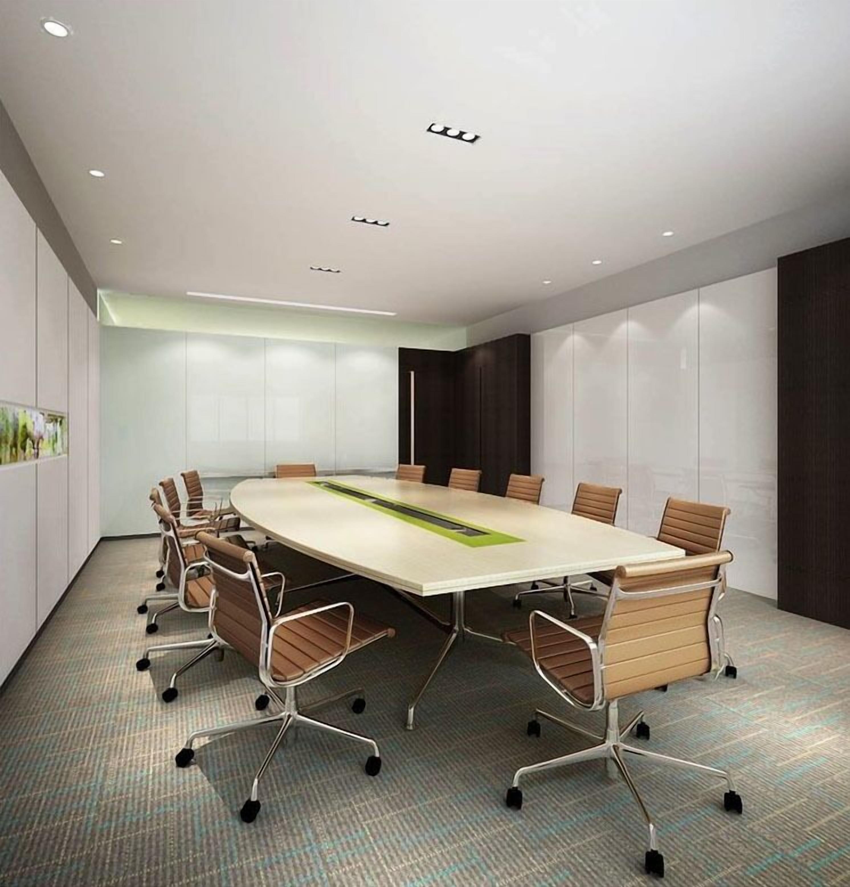Une salle de conférence dotée d’une grande table ovale, de nombreuses chaises et d’un sol recouvert de moquette.