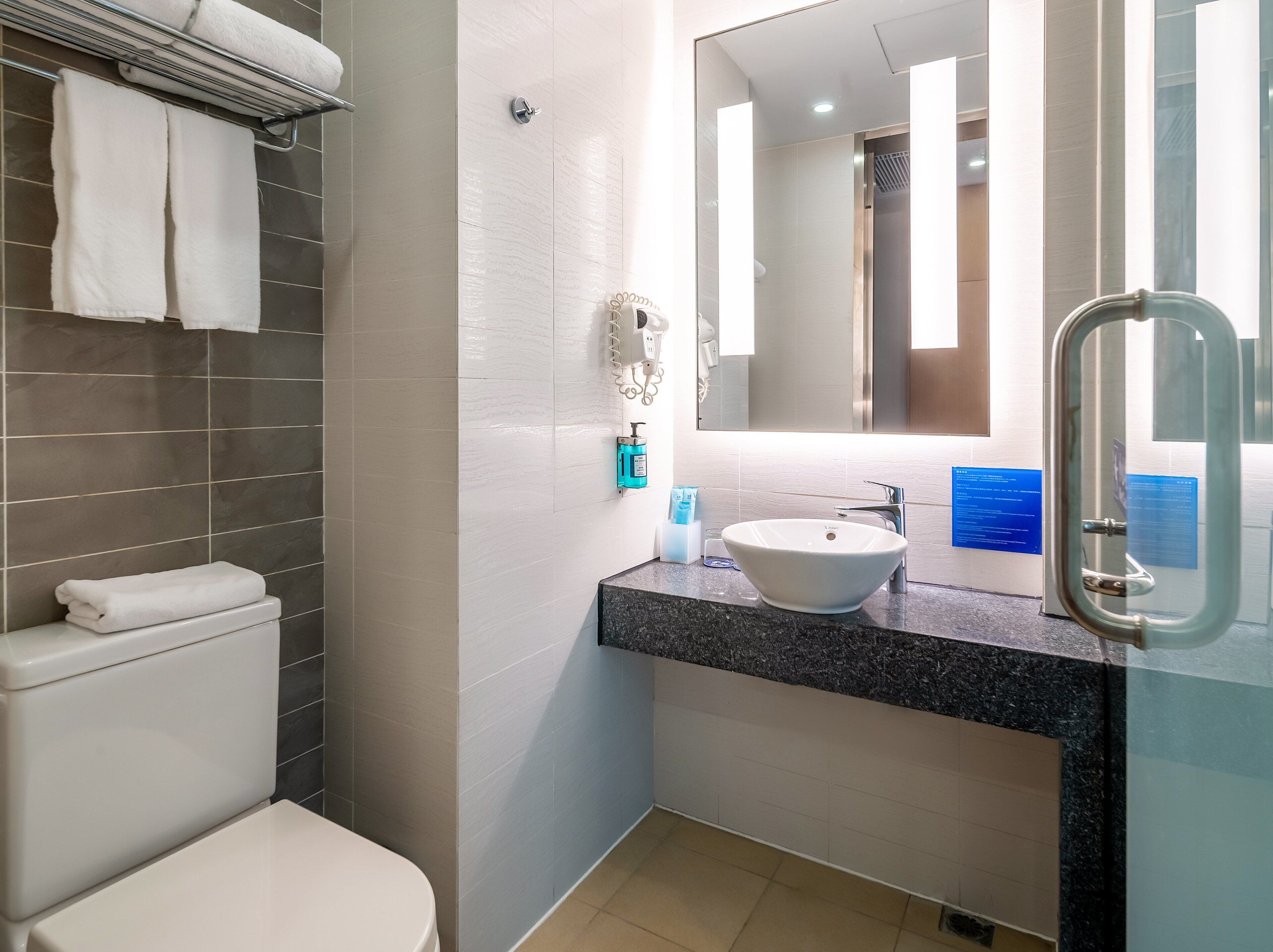 A modern bathroom with a toilet, a sink, and a shower.
