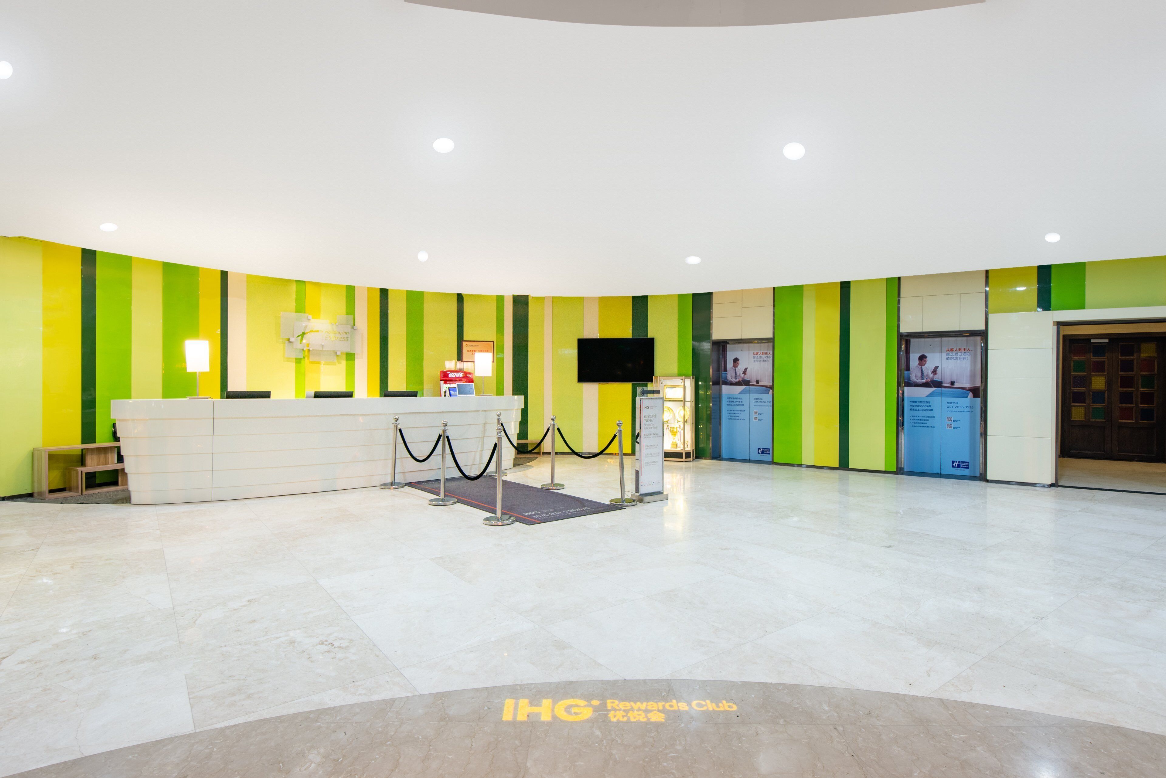 A reception area with a counter, a television, and a signboard.