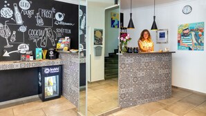A reception area with a chalkboard menu, a refrigerator labeled 'kukkis Cocktail', and a patterned counter. - Auto-Parkhotel (Hamburg)