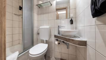 Ein modernes Badezimmer mit Toilette, Waschbecken und Dusche.
