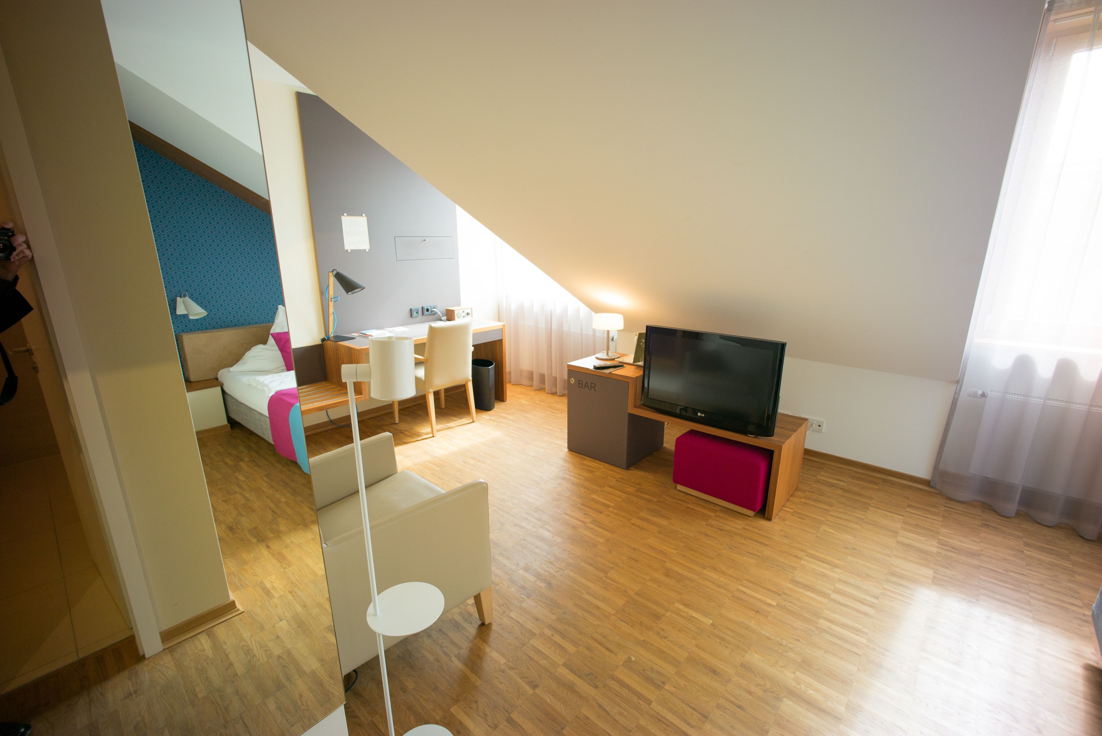 Een moderne, goed verlichte woonkamer met een flatscreen televisie, een eethoek en een gezellige zithoek.