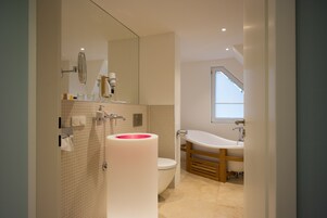 A modern bathroom with a toilet, sink, and bathtub.