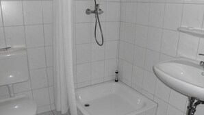 A bathroom with a toilet, a bathtub, and a sink. - Central Hotel Eberswalde (Eberswalde)