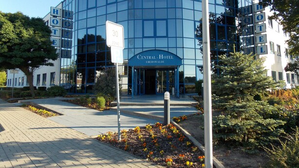 A modern hotel with a glass facade, a central entrance, and a sign indicating a 30-minute parking zone. - Central Hotel Eberswalde (Eberswalde)