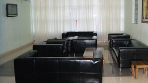 A spacious lobby with a large seating area, a reception desk, and a painting on the wall. - Hotel Monte Carlo (Enugu)