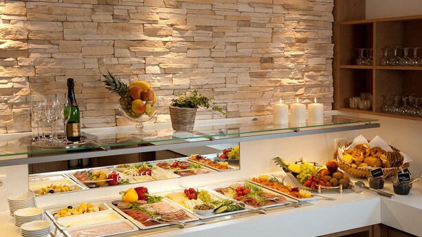 A buffet with various food items and a bottle of champagne. - Landhotel Postwirt (Grafenau)
