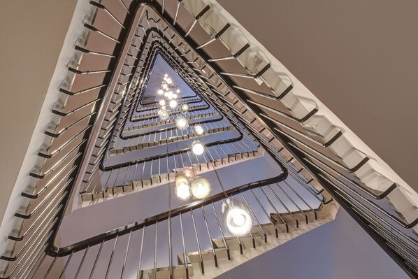 Una escalera de caracol con barandillas de metal e iluminación.