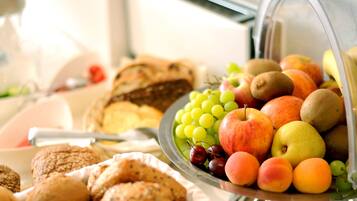 Ein reichhaltiges Frühstücksbuffet mit Obst, Brot und Backwaren.