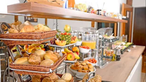 A buffet with various food items including bread, fruits, and beverages. - Hotel Herrenhof (Lübeck)