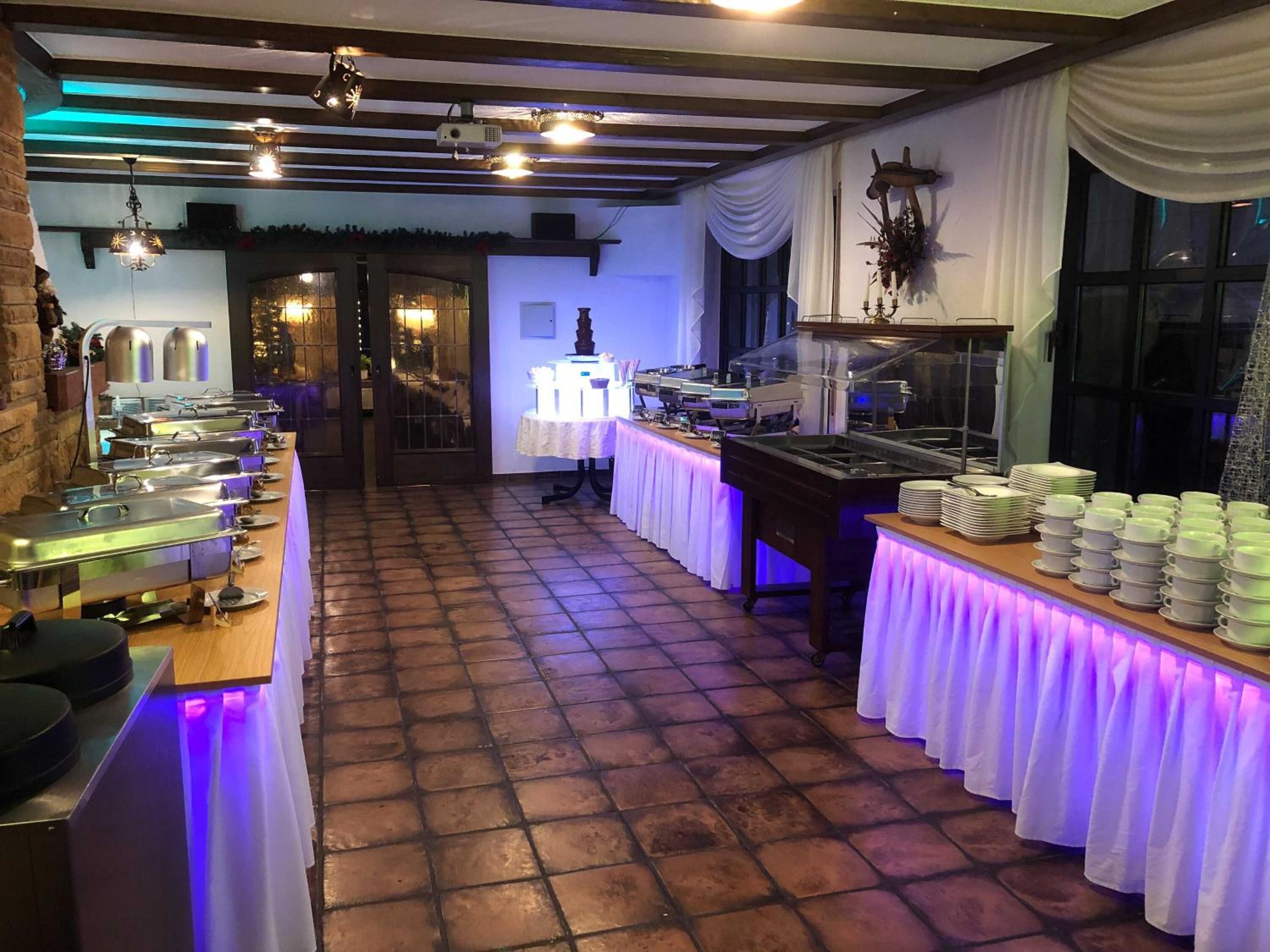 Una mesa de buffet con varias estaciones de servicio y piso de baldosas.